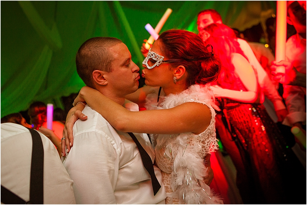 Couple kisses on the dance floor at their tented reception at Fairchild Gardens in Miami 