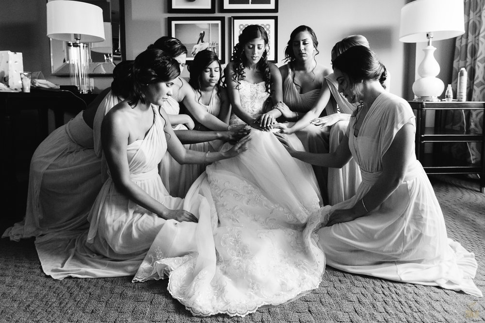 Bride prays with bridesmaids