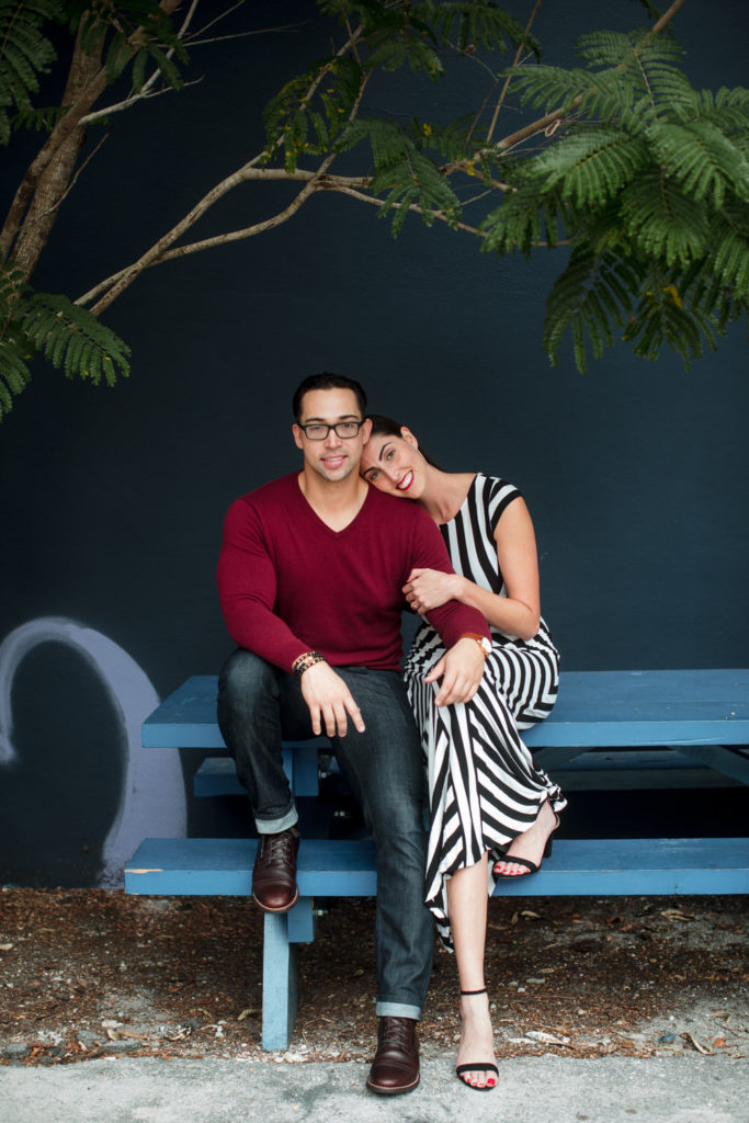 Engaged couple sitting on a picnic table in Wynwood Miami