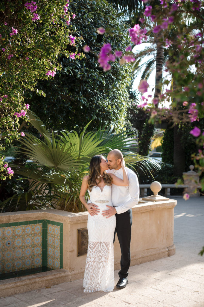 Couple poses in bougainvillea courtyard off Worth Ave in Palm Beach Florida 
