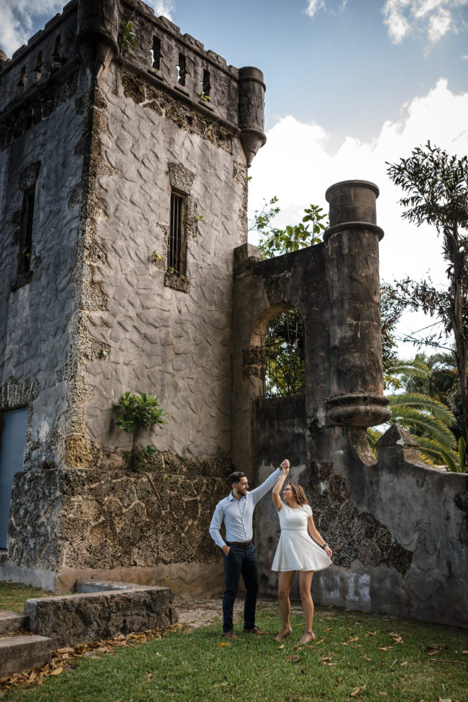 Groom twirls his bride to be at the towers of Coral Gables Wayside Park
