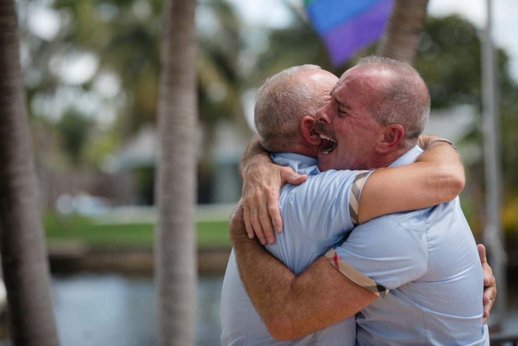 Two grooms hug each other at the end of their ceremony during their LGBTQ South Florida Wedding 
