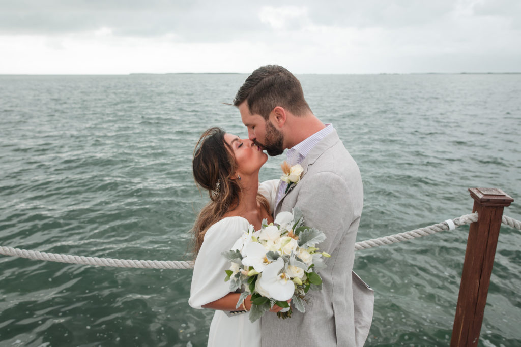 Bride and groom kiss on the docks of Key Largo in the Florida Keys