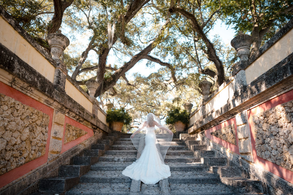 Photograph of bride from behind as she poses on the steps of the mound at Vizcaya in Coconut Grove Miami
