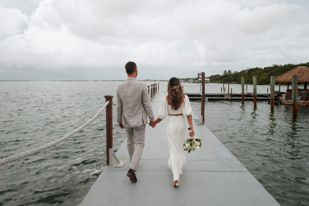 A newlywed couple walks away on a dock at Bakers Cay Resort, a fantastic South Florida Wedding Locations