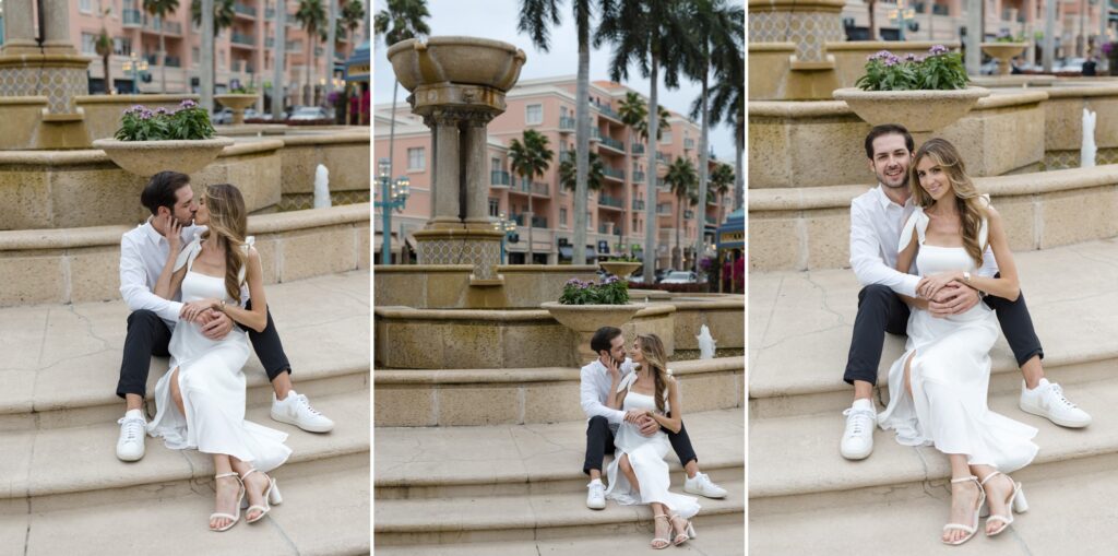 Images of an engaged couple - she's in a white dress and he's wearing black pants and a white shirt and they're cuddling on the steps of a fountain in Mizner Park